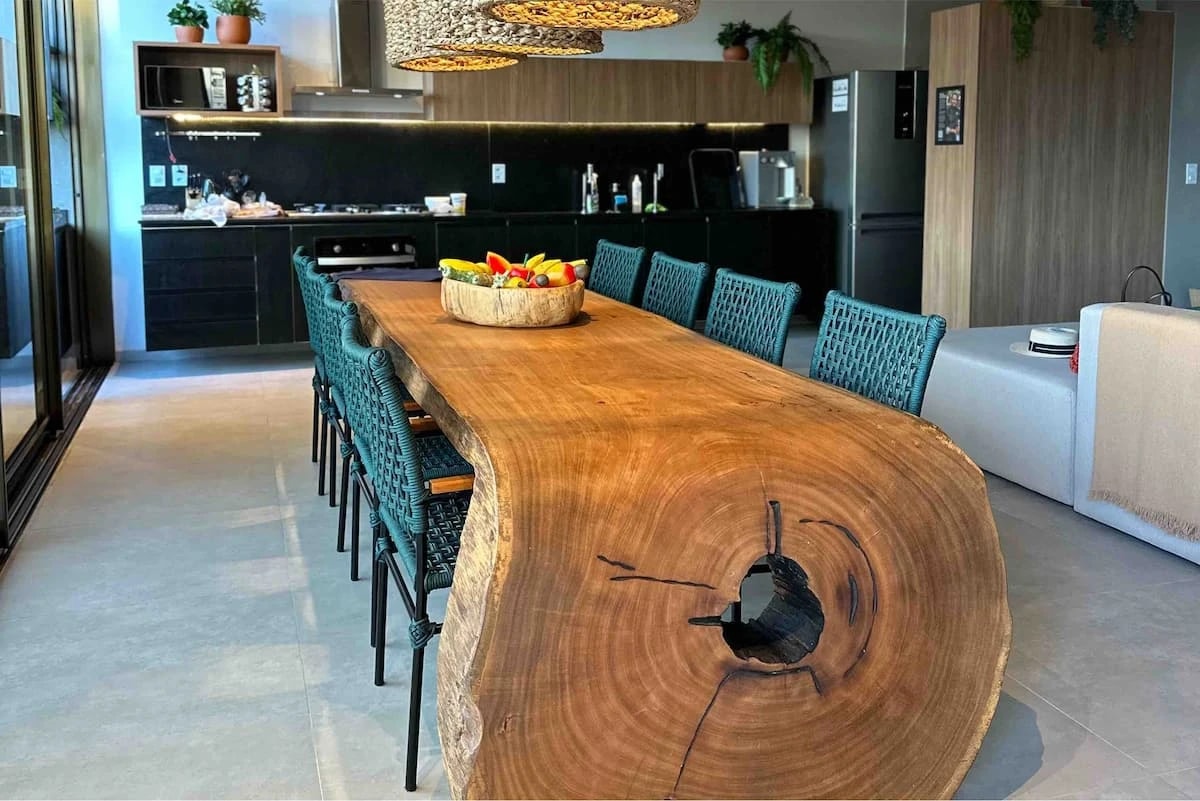 A mesa de jantar em madeira maciça, peça central da cobertura.
